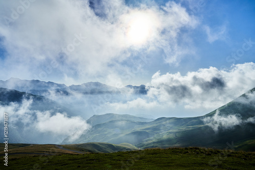 Landscape in the moutains with light clouds and sun behind the clouds © Sylvain