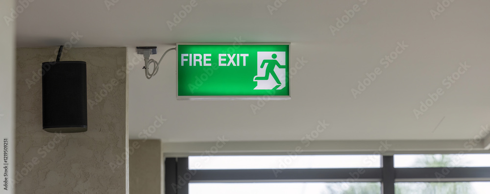 Green emergency exit sign showing the way to escape. Green emergency exit sign showing the way to escape.