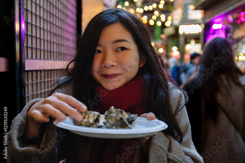Photography Young woman eating oysters at christmas market in london