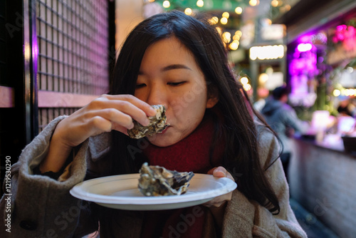 Wall Mural Young woman enjoying fresh oysters at borough market london