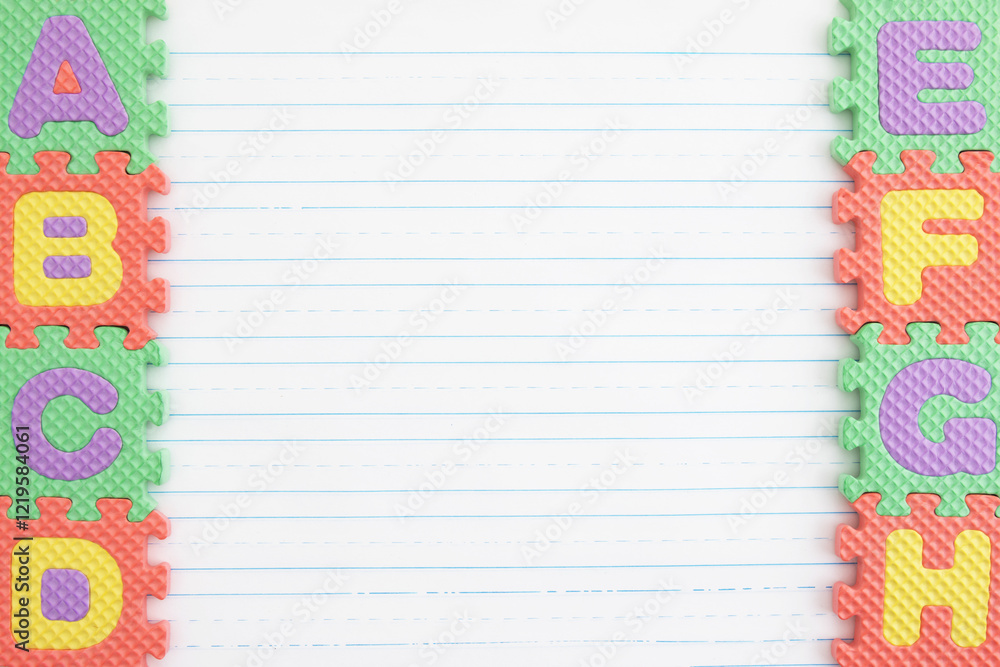 Obraz premium ABC puzzle pieces on lined paper background