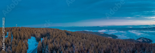 Obraz na płótnie Epic drone panorama of Rogla ski resort in Pohorje region of Slovenia. Visible colorful sunset, clouds in the valley and small hills piercing through the clouds. w salonie