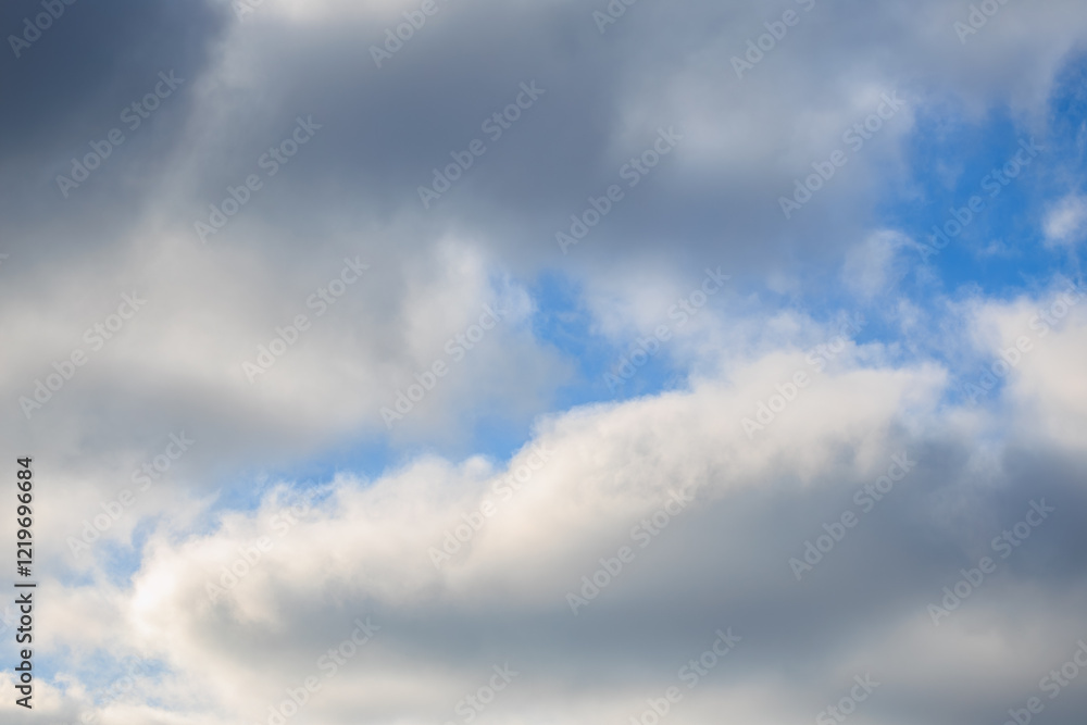 Dramatic cloudscape with bright blue sky peeking through voluminous clouds Dramatic cloudscape with bright blue sky peeking through voluminous clouds