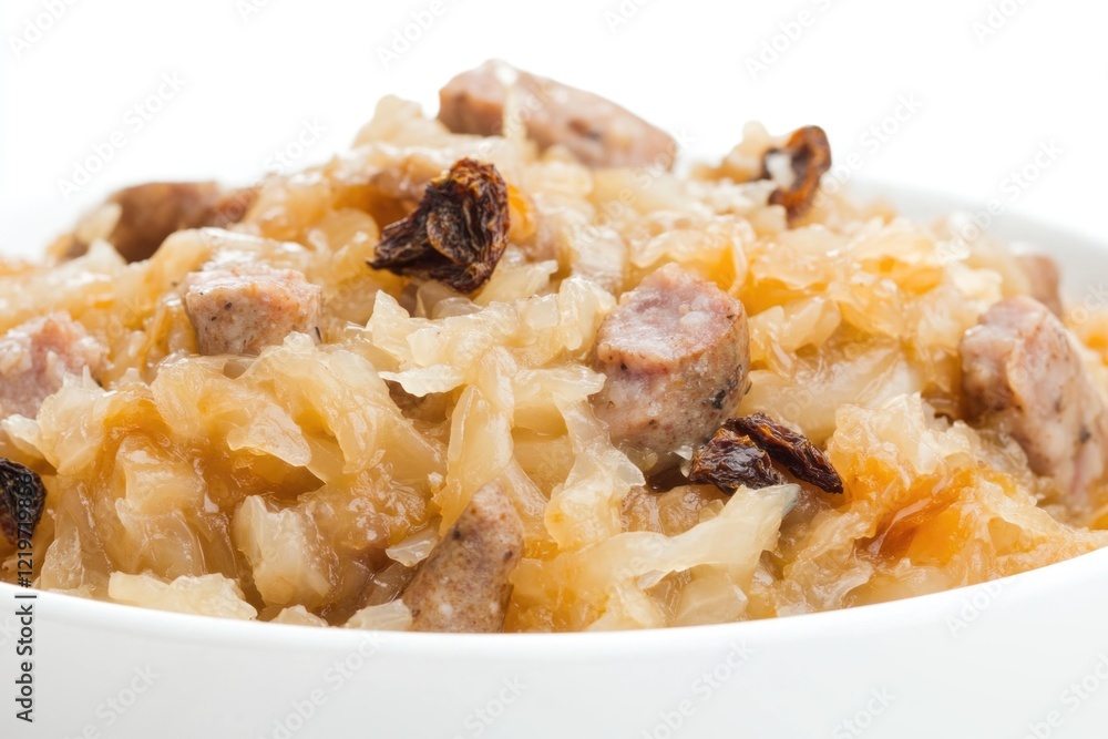 A bowl of fermented sauerkraut with chunks of meat and sweet raisins A bowl of fermented sauerkraut with chunks of meat and sweet raisins