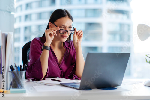 Fotografie Businesswoman taking off glasses and looking at laptop screen confused blurry vi