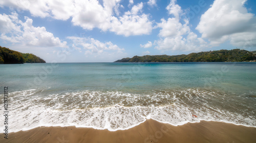 Foto Gentle waves roll onto the sandy beach at Kings Bay ,crystal-clear turquoise water, the vast horizon and soft clouds create a peaceful, untouched tropical paradise