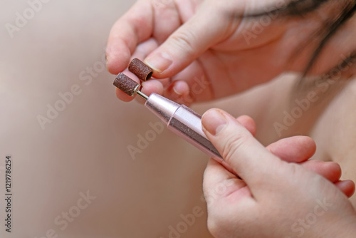 women's hands comparing the coarseness of abrasive coatings on nail and skin cleaning attachments. Perfect for beauty, nail care, and personal grooming themes photo