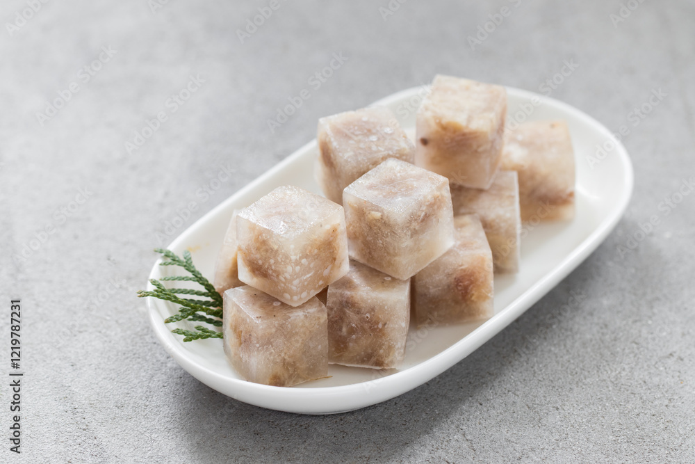 Aspic. Jellied meat in the shape of a mini cubes. On a plate. Light gray background. Close up Aspic. Jellied meat in the shape of a mini cubes. On a plate. Light gray background. Close up
