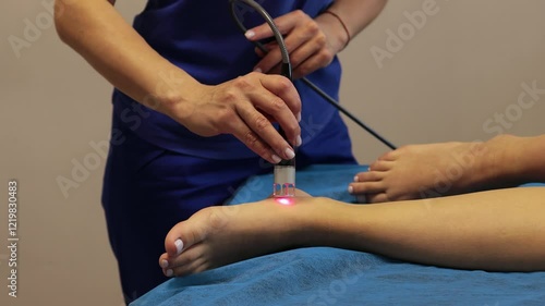 Laser feet therapy to heal from chronic heel pain 4k video. Woman is going through infrared procedure to relieve painful foot conditions, heal from injury and arthritis.