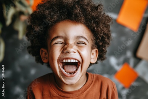 A close-up of a child with their mouth wide open in laughter, their eyes squinting with pure joy at something amusing photo