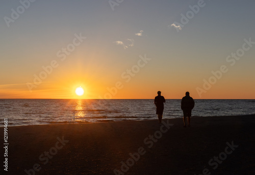 Photos Two male friends watching the Georgian Bay sunset from the beach on a late summe