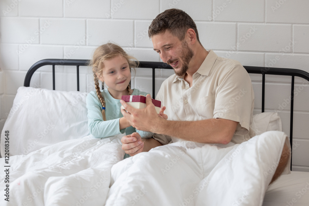 Obraz premium Father and daughter enjoy a joyful morning together as she surprises him with a gift in their cozy bedroom