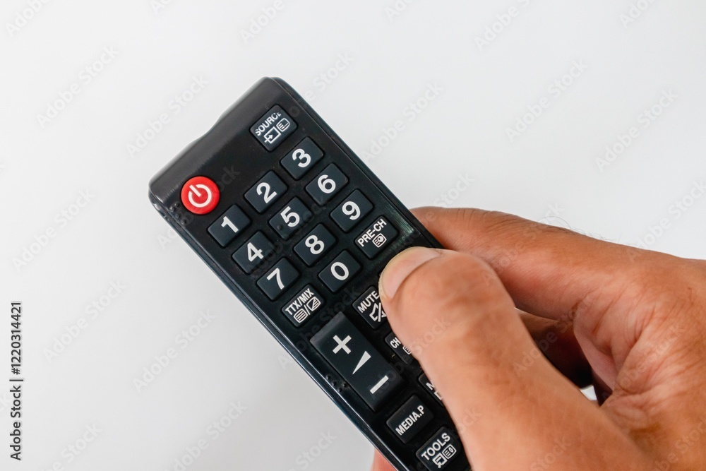 Hand holding a tv remote with many buttons on white background Hand holding a tv remote with many buttons on white background