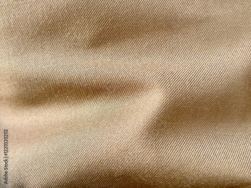 Close-up of khaki textile fabric with a smooth texture and subtle folds, showcasing the fine weave and natural color. Ideal for fashion and abstract background design