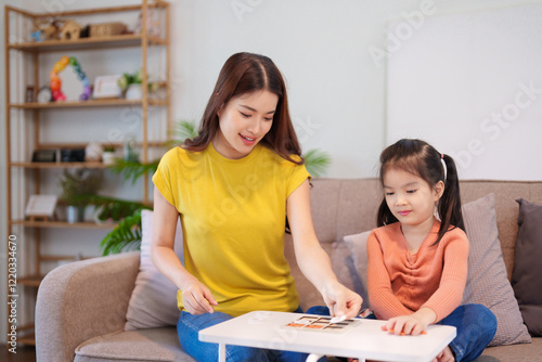  A mother and daughter enjoying a playful game of tic-tac-toe together on a table, sharing laughter and connection.