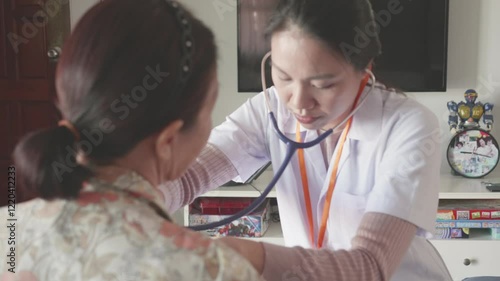 A healthcare professional conducts a patient examination in a clinic, using a stethoscope to check vital signs. The warm interaction emphasizes the importance of healthcare and patient care in a suppo photo