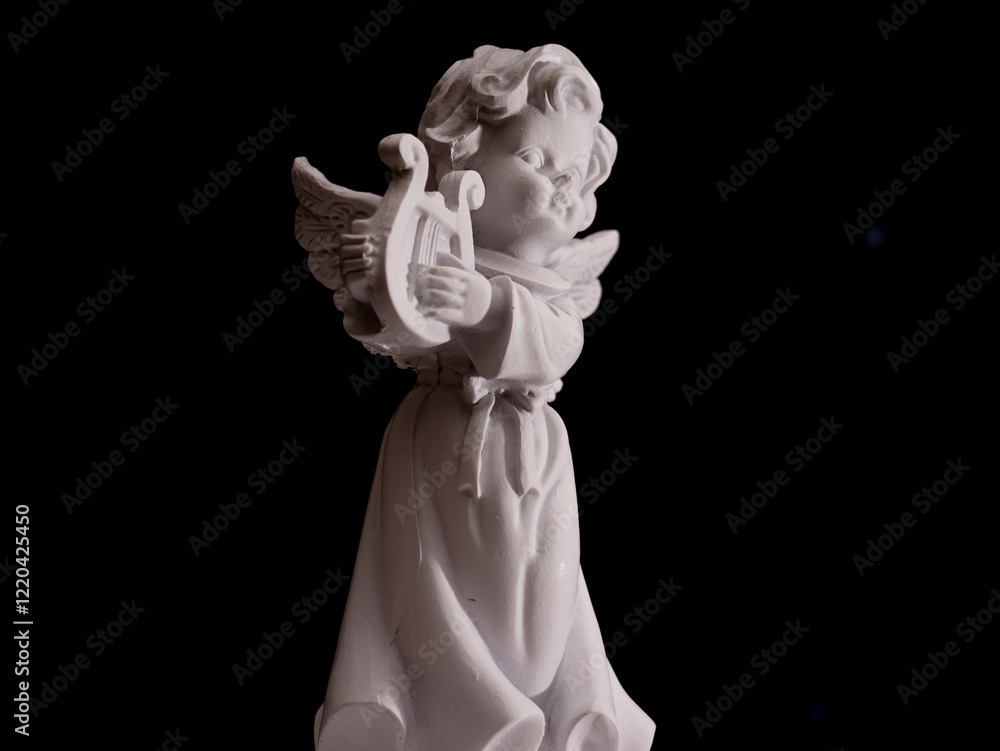 Naklejka premium A white angel statue holding a harp