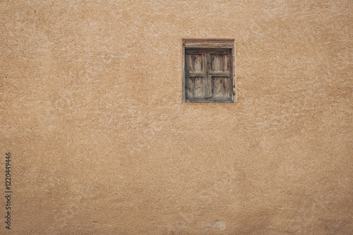 Old window on Pale yellow wall. Ancient traditional residential old house wall and wooden window