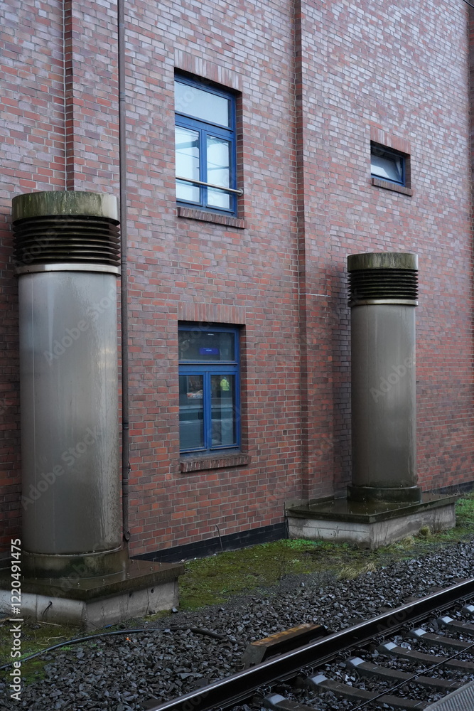 Naklejka premium Abluftrohre an einem Gebäude neben Eisbahnschienen