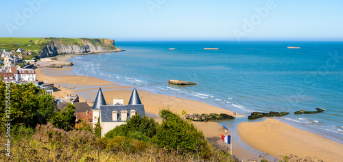 Panoramic view over Arromanches beach and Cap Manvieux in Normandy, France, on a sunny day, with remains of the WWII artificial Mulberry harbor lying on the sand and in the sea. photo