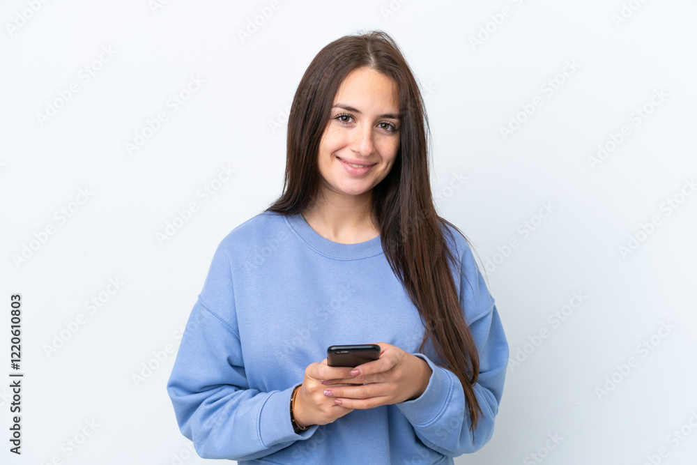 Young Ukrainian woman isolated on white background looking at the camera and smiling while using the mobile Young Ukrainian woman isolated on white background looking at the camera and smiling while using the mobile