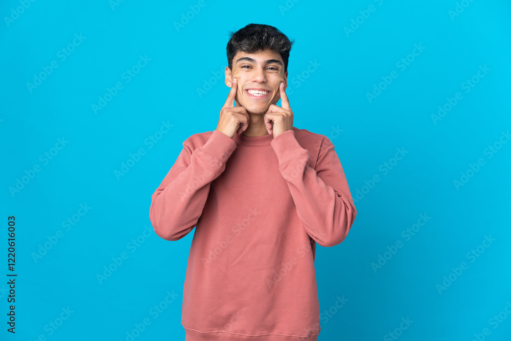 Young man over isolated blue background smiling with a happy and pleasant expression Young man over isolated blue background smiling with a happy and pleasant expression