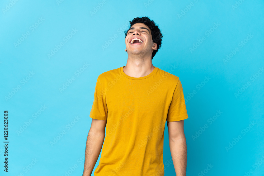 Young Venezuelan man isolated on blue background laughing Young Venezuelan man isolated on blue background laughing