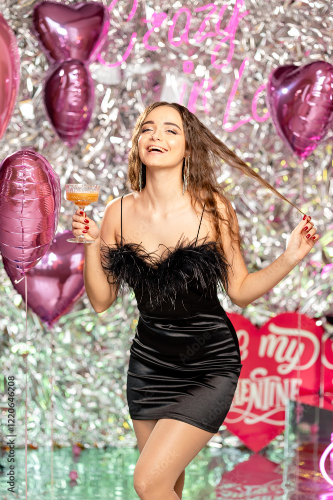 portrait of a smiling girl in a black dress with a cocktail in her hands, who is having fun celebrating Valentine's Day portrait of a smiling girl in a black dress with a cocktail in her hands, who is having fun celebrating Valentine's Day