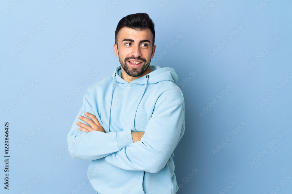 Caucasian man over isolated blue background with arms crossed and happy Caucasian man over isolated blue background with arms crossed and happy
