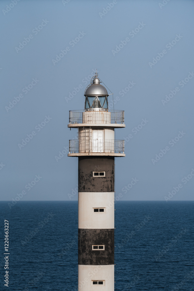 Faro blanco y negro con mar de fondo Faro blanco y negro con mar de fondo