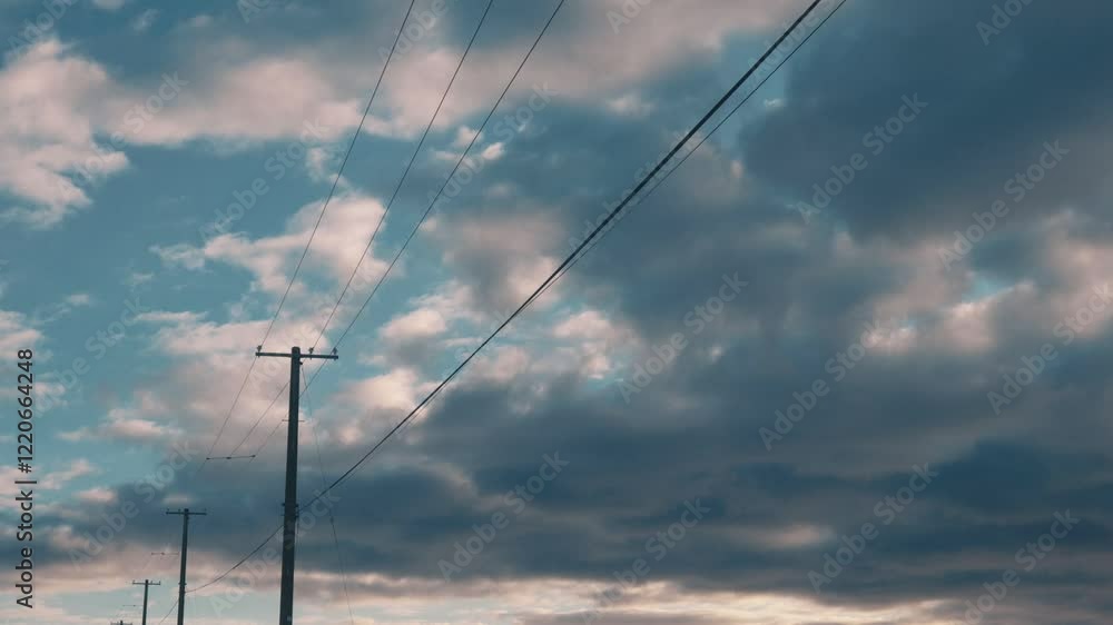 夕日のまだら雲と並んだ電柱のシルエット