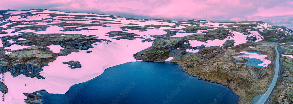 Panoramic aerial view of snowy mountains in summer. Bjørgavegen high mountain road and Flotevatnet lake. Aurlandsvegen, Aurland, Norway. Horizontal banner