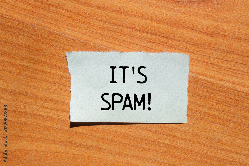 It's spam message written on ripped torn paper piece with wooden background. Conceptual it's spam symbol. Copy space. It's spam message written on ripped torn paper piece with wooden background. Conceptual it's spam symbol. Copy space.