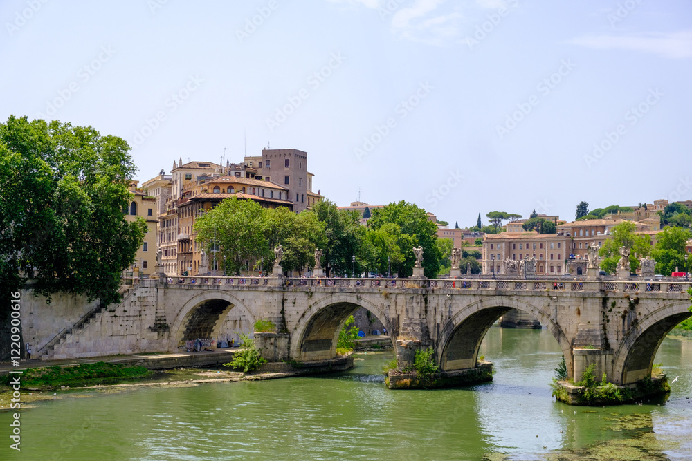 A beautiful bridge spans a river with buildings in the background