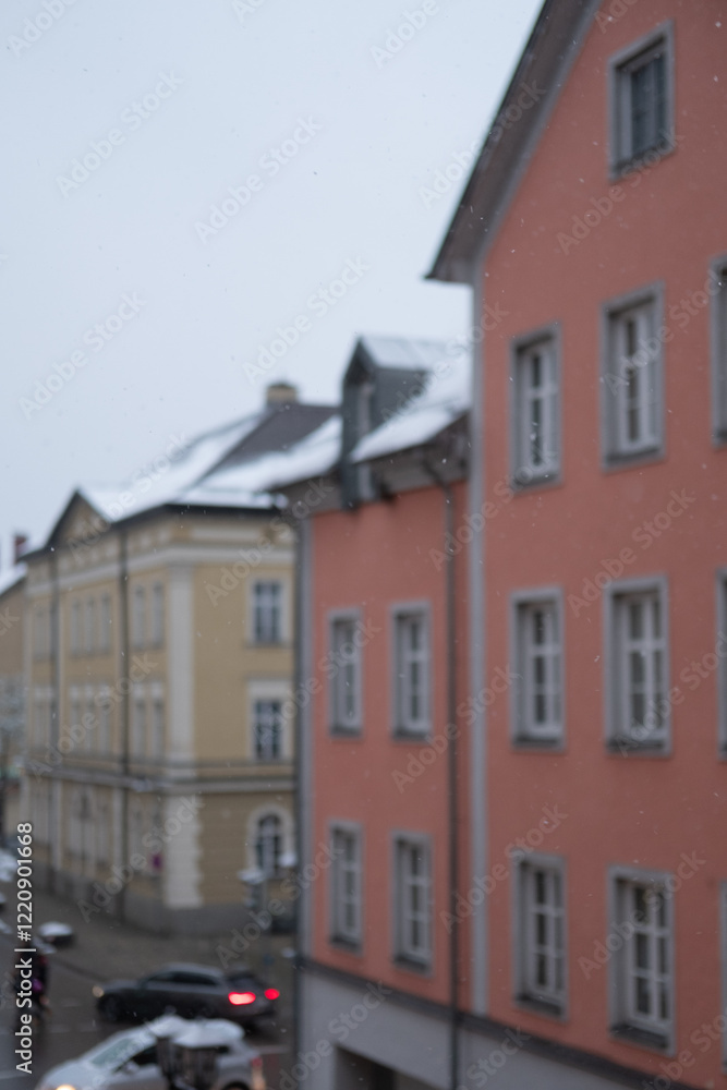 Obraz premium Blurred image of Snow falling - with windows, building on the background.