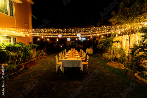 Summer winter candle light dinner party theme with fine dinning arrangements fairy lights and latrines in garden!      photo