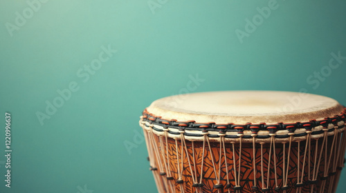 Traditional drum with intricate patterns against teal background photo