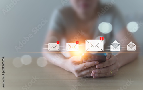 A woman sits and checks her email inbox to open it, whether it's for business or spam, using her mobile phone at home. convenient life, borderless communication with modern technology Background blur