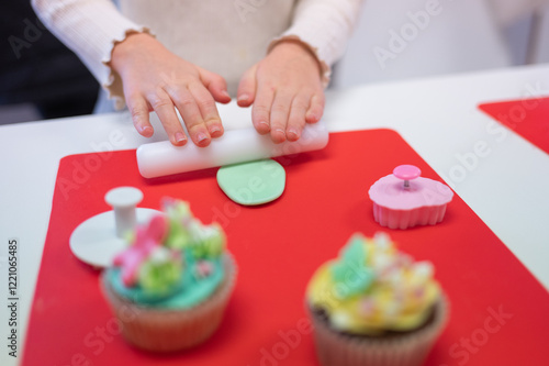 Young girl decorating cupcakes during a baking class preparing muffins and cupcake for birthday party celebration
