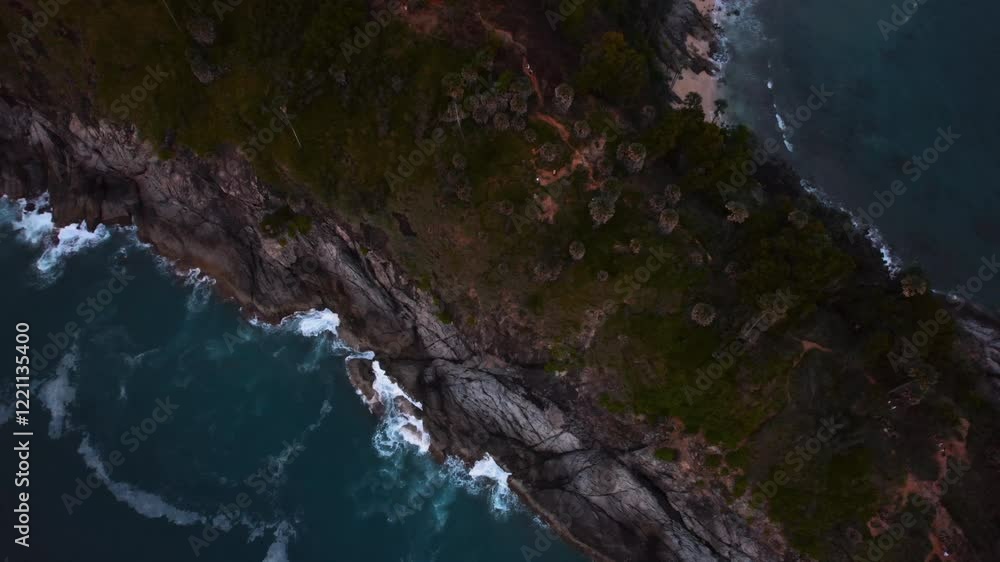 Tropical rocky coastline meeting ocean waves at dusk Tropical rocky coastline meeting ocean waves at dusk