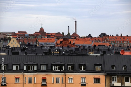 Obraz na płótnie Rooftop cityscape with chimneys in stockholm, showcasing red-tiled roofs and urban density w salonie