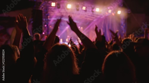 Vibrant live concert scene with band performing on stage under bright spotlights. People enjoying live music performance at an outdoor concert