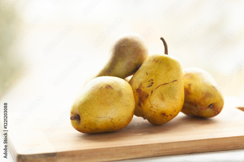 Ripe yellow pears on a wooden cutting board, ready for use in a recipe or dessert. A rustic and natural still life. Ripe yellow pears on a wooden cutting board, ready for use in a recipe or dessert. A rustic and natural still life.
