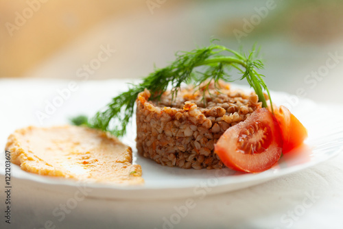 Foto Buckwheat dish with tomato and creamy sauce garnish