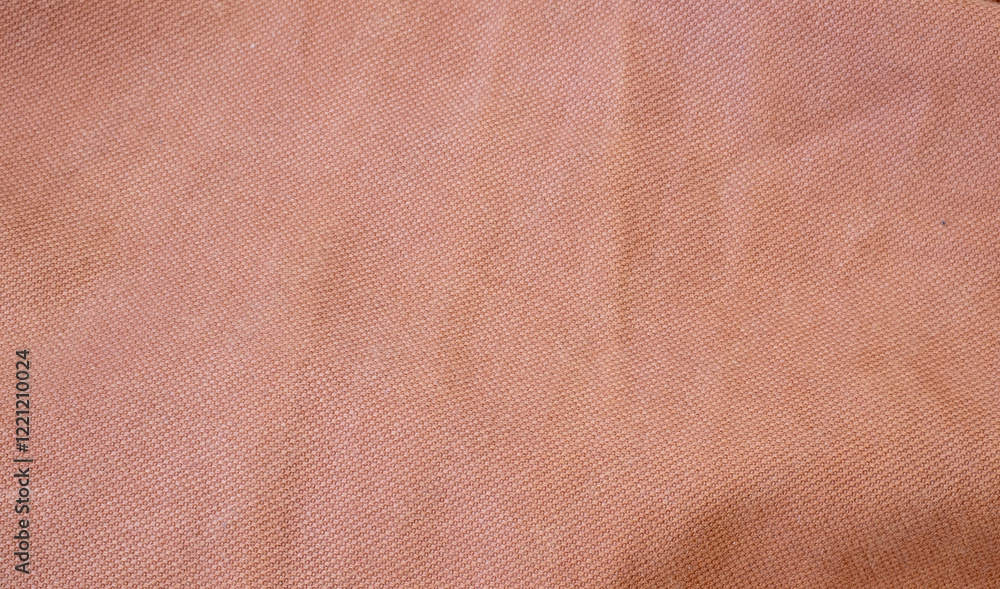 Fototapeta premium Soft, textured fabric in warm peach color, ideal for backgrounds, fashion shoots, or product photography. Perfect for adding warmth and depth to visuals.