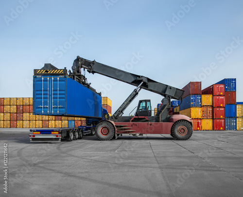 Photos A crane is lifting a blue container off a truck