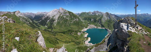 Panoramic view from Plattnitzerjochpitze with its summit cross Spullersee reservoir and the mountains of Spullerschafberg and Grätligrat and Rohnspitze in the Austrian region of Vorarlberg photo