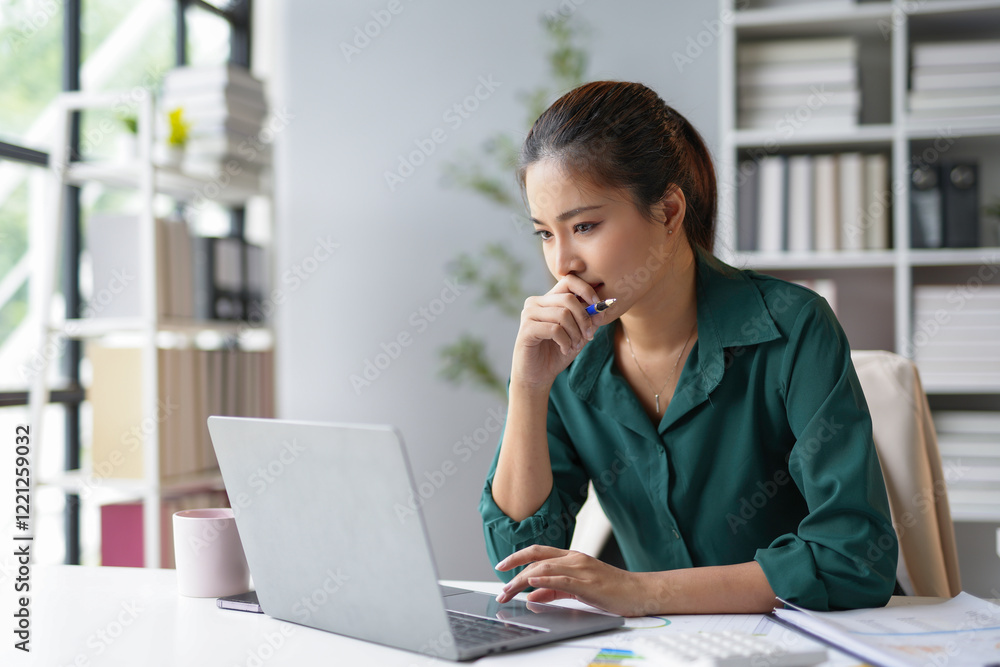 Focused businesswoman working with laptop and thinking about project in modern office Focused businesswoman working with laptop and thinking about project in modern office