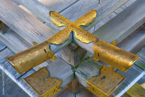 Kyoto, Japan - Sep 23 2024, A close-up view of a wooden railing covered with metallic gilded elements with patterns, in Fushimi Insri shrine, at daytime, Kyoto, Japan photo