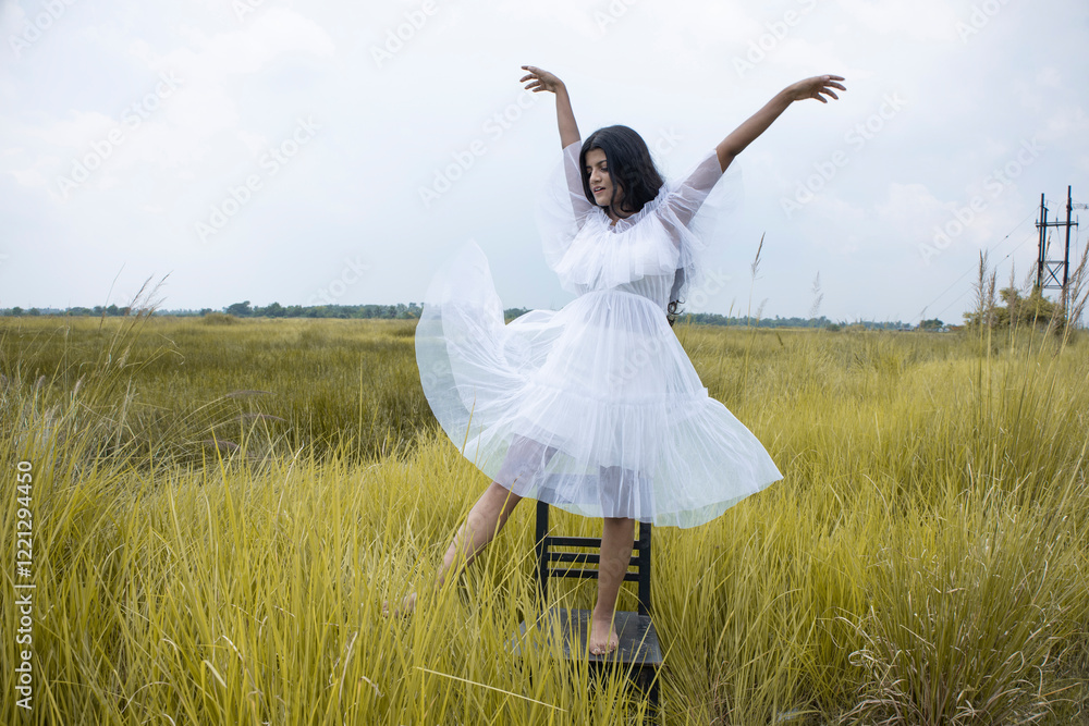 a young Indian female model with black hair, wheatish skin, Indian features wearing a white skirt and posing int he middle of an open grass field a young Indian female model with black hair, wheatish skin, Indian features wearing a white skirt and posing int he middle of an open grass field